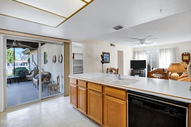 kitchen with ceiling fan, black dishwasher, sink, and a textured ceiling