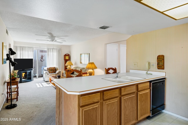 kitchen featuring sink, ceiling fan, black dishwasher, a textured ceiling, and kitchen peninsula