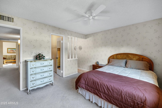 bedroom featuring ceiling fan, carpet floors, and a textured ceiling