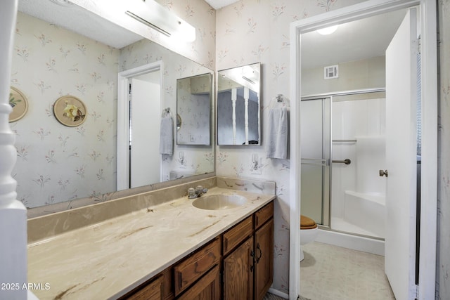 bathroom with vanity, toilet, and a shower with door