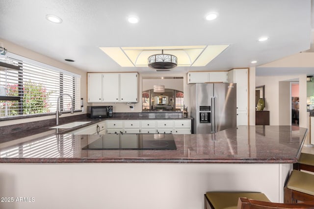 kitchen featuring a sink, white cabinets, black appliances, dark stone countertops, and recessed lighting