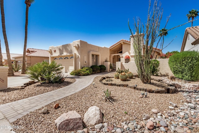 adobe home with a garage, stucco siding, a tiled roof, and fence