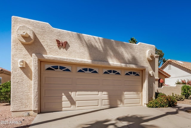 garage featuring concrete driveway