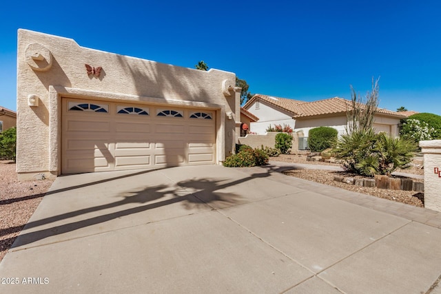 view of front of house with concrete driveway, stucco siding, and a garage