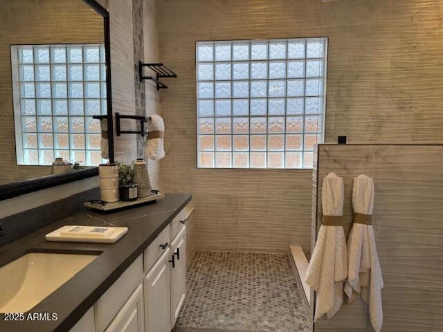 bathroom featuring vanity, a healthy amount of sunlight, and walk in shower