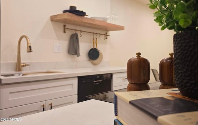 kitchen with white cabinetry, dishwasher, and sink