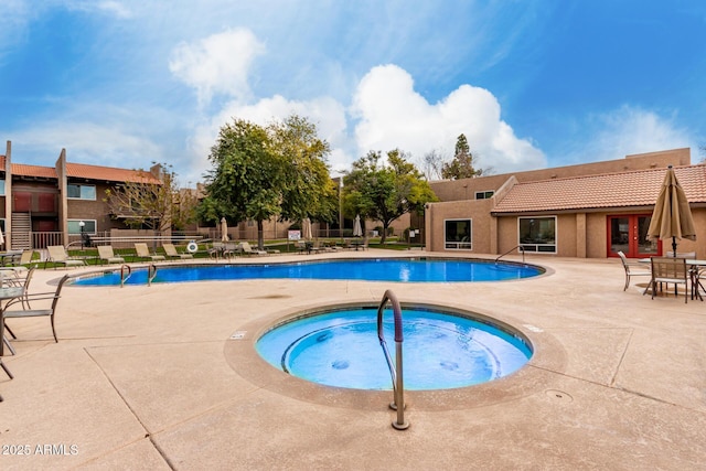 view of pool featuring a hot tub and a patio