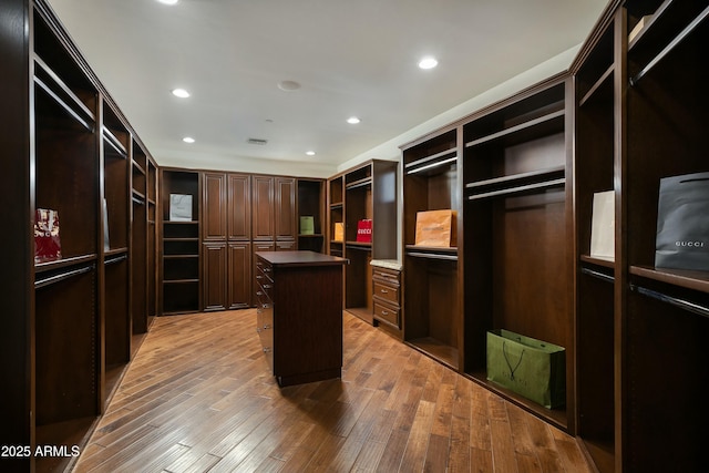 walk in closet with visible vents and wood finished floors