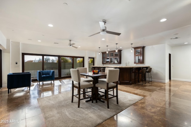 dining room with ceiling fan, recessed lighting, indoor bar, visible vents, and baseboards