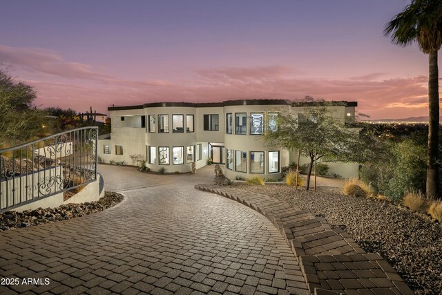 view of front facade with decorative driveway and stucco siding