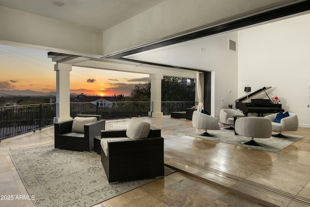 patio terrace at dusk featuring visible vents and an outdoor hangout area