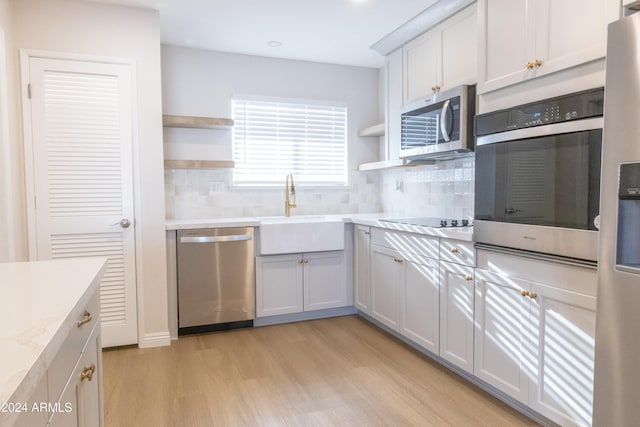 kitchen featuring white cabinets, sink, light wood-type flooring, and stainless steel appliances