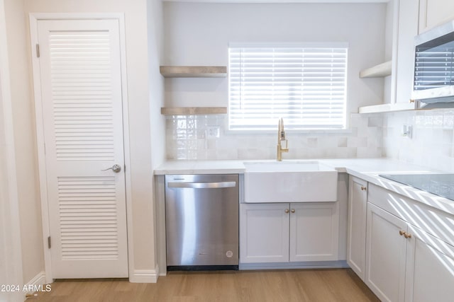 kitchen with decorative backsplash, stainless steel appliances, light hardwood / wood-style flooring, and sink