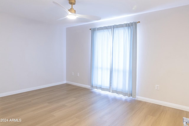 spare room with ceiling fan and light wood-type flooring