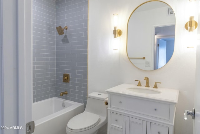 full bathroom featuring vanity, tiled shower / bath combo, and toilet