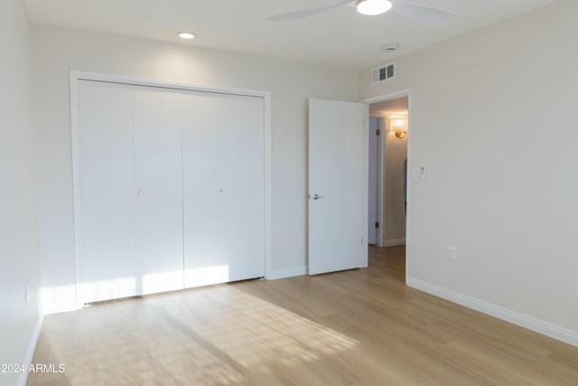 unfurnished bedroom with a closet, light hardwood / wood-style flooring, and ceiling fan