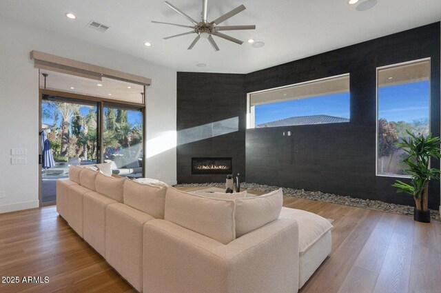 815 E County Down Dr, Chandler, AZ 85249 - living room with light wood finished floors, visible vents, a ceiling fan, a glass covered fireplace, and recessed lighting