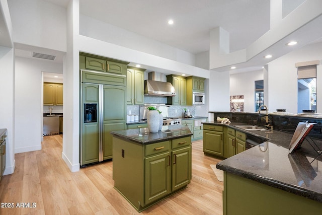 815 E County Down Dr, Chandler, AZ 85249 - kitchen featuring wall chimney exhaust hood, a kitchen island, built in appliances, green cabinets, and a sink