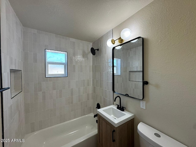 full bathroom with vanity, toilet, tiled shower / bath combo, and a textured ceiling