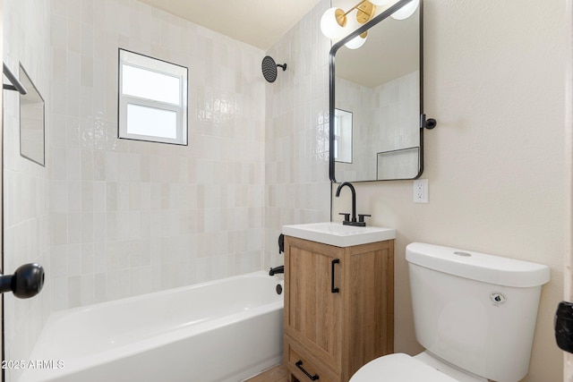 full bathroom featuring vanity, tiled shower / bath combo, and toilet