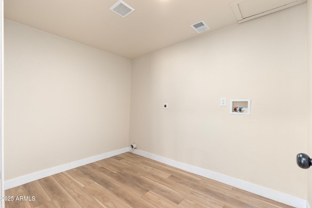 washroom featuring electric dryer hookup, hookup for a washing machine, and light hardwood / wood-style floors