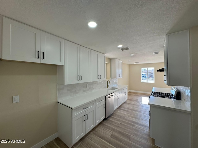 kitchen featuring sink, decorative backsplash, stainless steel dishwasher, and white cabinets