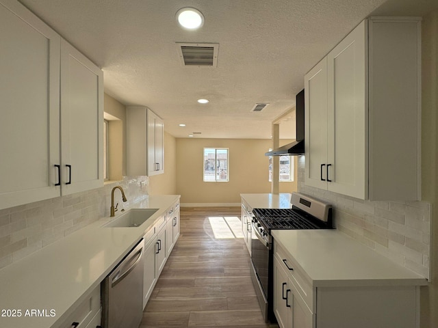 kitchen featuring stainless steel appliances, white cabinetry, sink, and decorative backsplash