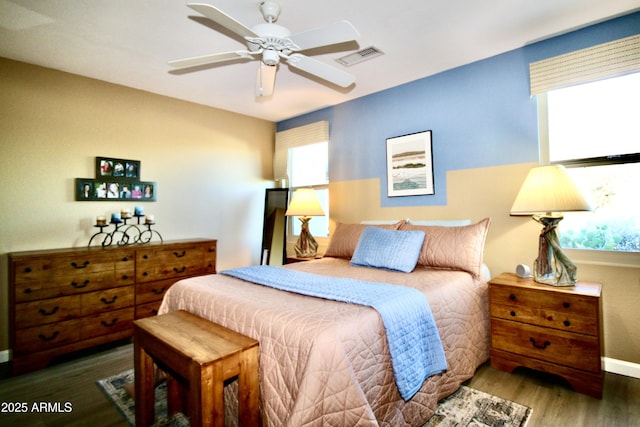 bedroom with multiple windows, dark hardwood / wood-style flooring, and ceiling fan