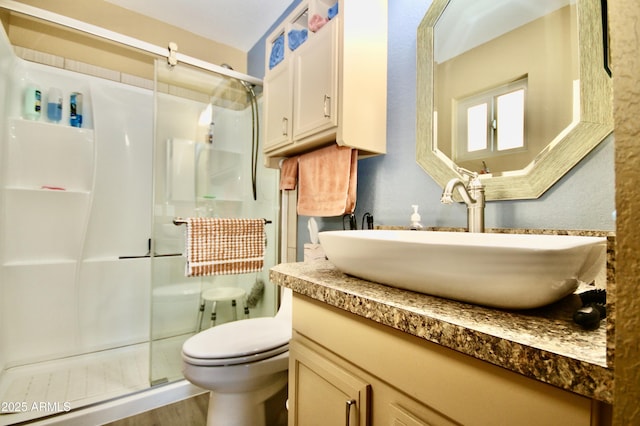 bathroom with a shower with door, vanity, hardwood / wood-style floors, and toilet