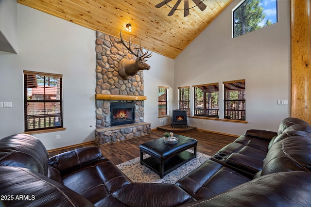 2295 Bison Ranch Trl, Overgaard, AZ 85933 - living room with high vaulted ceiling, wood finished floors, a wood stove, a ceiling fan, and a stone fireplace
