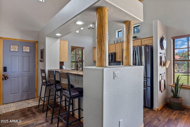 2295 Bison Ranch Trl, Overgaard, AZ 85933 - kitchen featuring freestanding refrigerator, ornate columns, light brown cabinetry, dark wood finished floors, and lofted ceiling