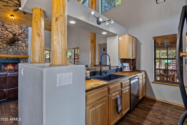 2295 Bison Ranch Trl, Overgaard, AZ 85933 - kitchen featuring wooden counters, dishwasher, dark wood-type flooring, a high ceiling, and a fireplace
