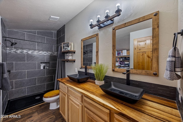 2295 Bison Ranch Trl, Overgaard, AZ 85933 - full bathroom featuring tiled shower, wood finished floors, double vanity, a textured wall, and a textured ceiling
