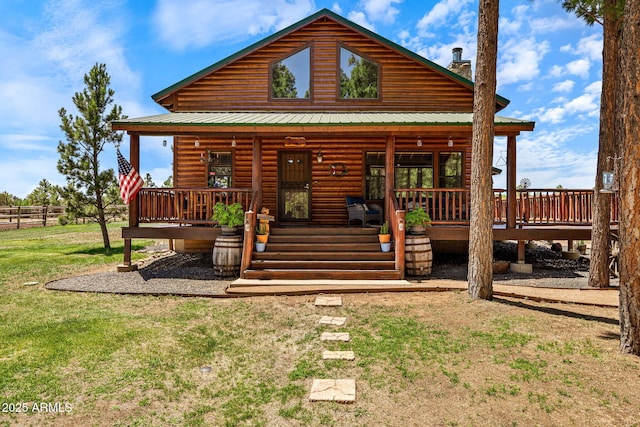 2295 Bison Ranch Trl, Overgaard, AZ 85933 - view of front of home featuring log veneer siding, a chimney, covered porch, and a metal roof