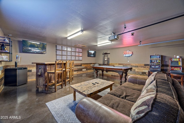 2295 Bison Ranch Trl, Overgaard, AZ 85933 - game room featuring concrete floors, a dry bar, billiards, a textured ceiling, and a wainscoted wall