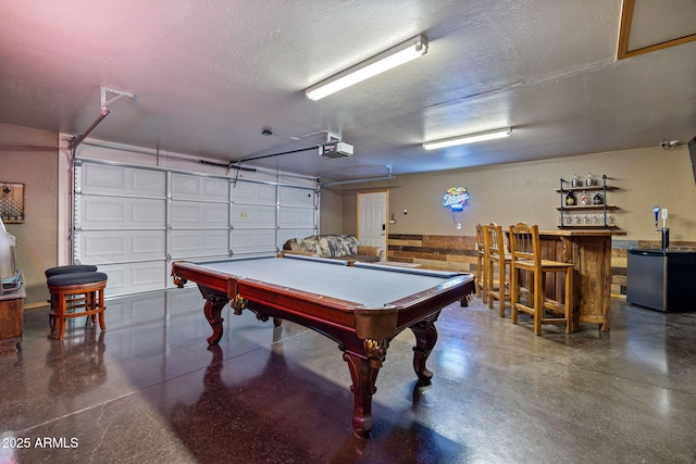 2295 Bison Ranch Trl, Overgaard, AZ 85933 - recreation room with finished concrete flooring, billiards table, a textured ceiling, a garage, and a dry bar