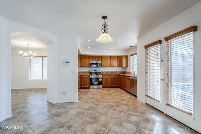 kitchen with stainless steel appliances, pendant lighting, and a chandelier