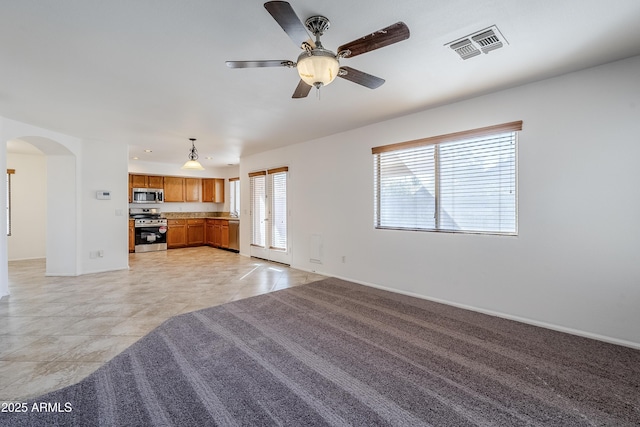 unfurnished living room featuring ceiling fan and light tile patterned floors