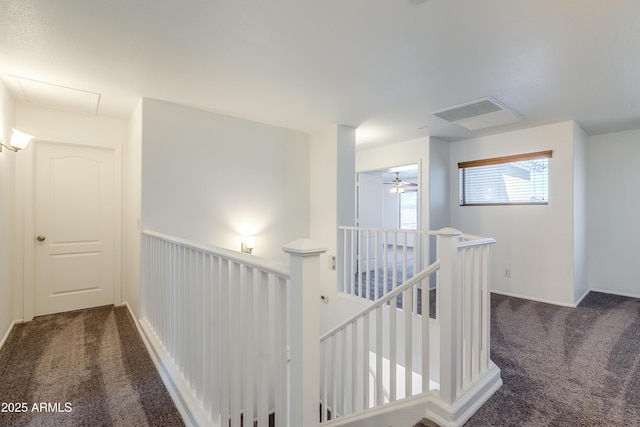 hallway with dark colored carpet