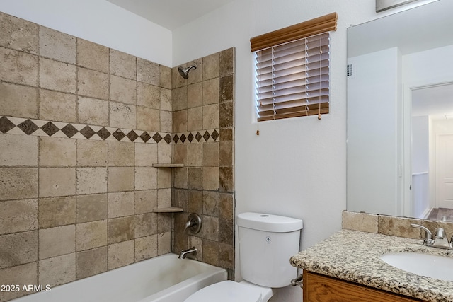 full bathroom featuring tiled shower / bath combo, vanity, and toilet