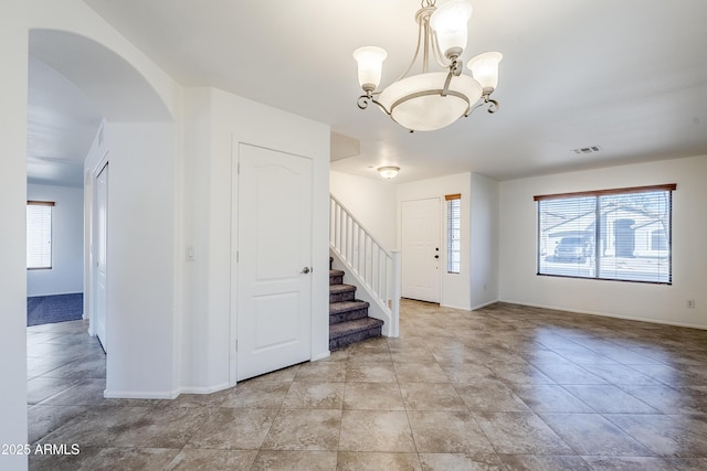 tiled entryway featuring an inviting chandelier