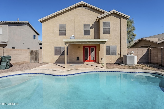 view of swimming pool featuring cooling unit, a patio area, and french doors