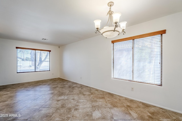 spare room with a notable chandelier