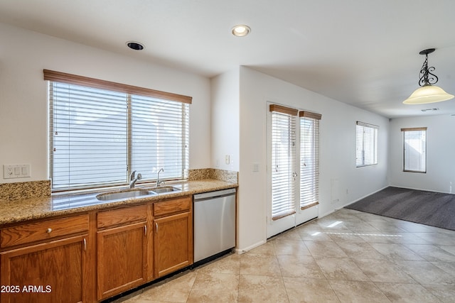 kitchen featuring pendant lighting, sink, light tile patterned floors, dishwasher, and light stone countertops