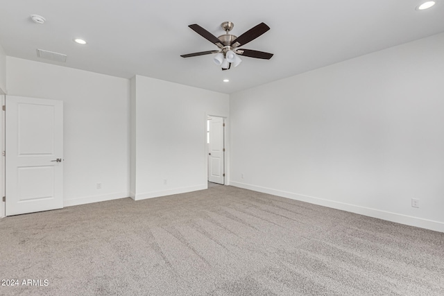 spare room featuring light carpet and ceiling fan