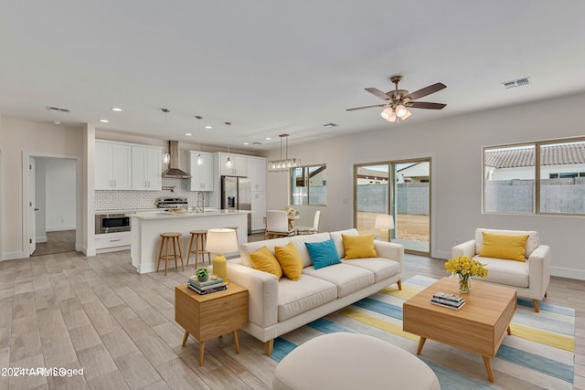 living room with ceiling fan, light wood-type flooring, and sink