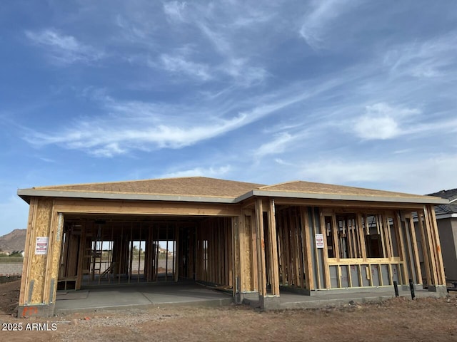 back of property with a shingled roof