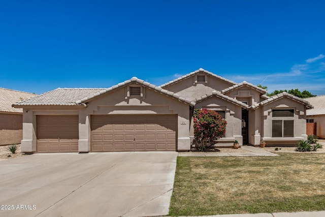 view of front of house featuring driveway, a tile roof, a garage, a front lawn, and stucco siding