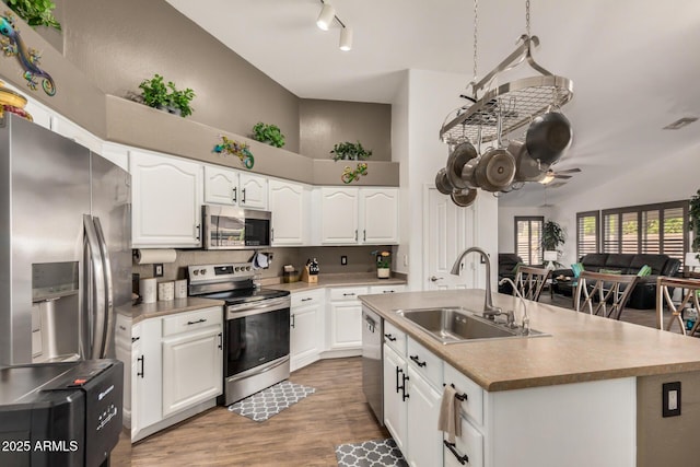 kitchen featuring a sink, white cabinetry, appliances with stainless steel finishes, and light wood-style flooring