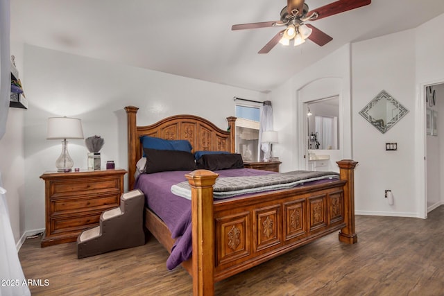 bedroom with baseboards, vaulted ceiling, wood finished floors, and connected bathroom